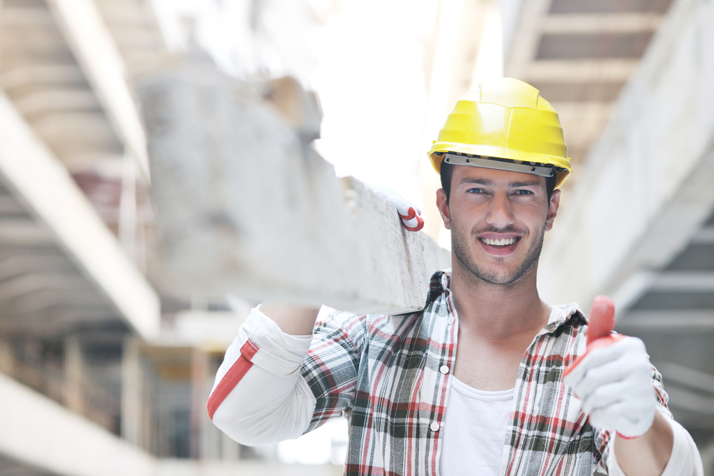 Man in hard-hat carries wooden plank